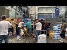 Shop owners and workers move crates at seafood market in Beijing