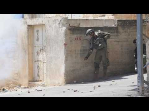 Palestinian demonstrators and Israeli soldiers clash in the West Bank
