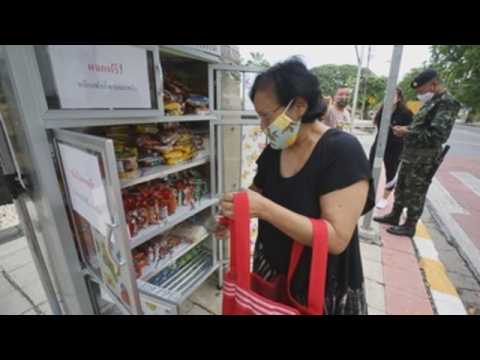People affected by coronavirus measures in Bangkok pick up free food