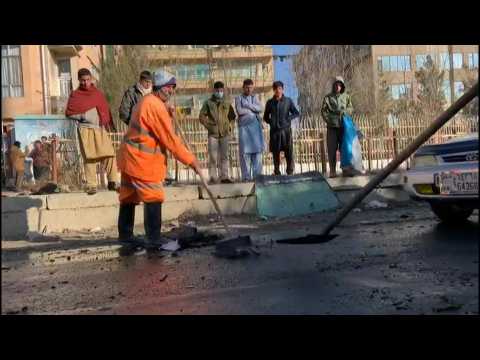 Men clean up street after deadly Kabul rocket attack