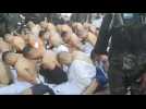 Honduras military police guard handcuffed inmates in prison