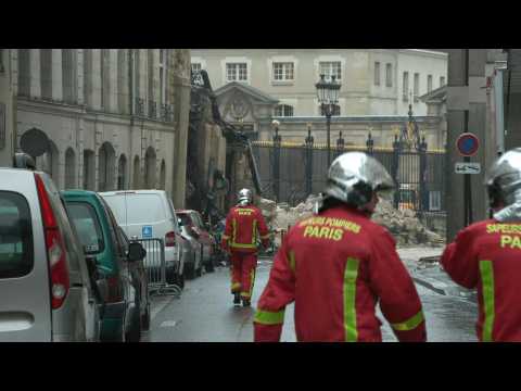 Firefighters and police near the collapsed building in Paris
