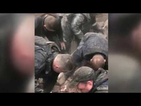 Ukrainian rescuers pull a woman out of the rubble after a strike in Kupiansk