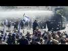 Israeli police use a water cannon to disperse protesters blocking road to parliament