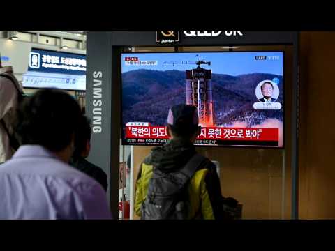 People in Seoul watch the news after North Korean military satellite crashes into sea