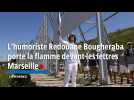 L'humoriste Redouane Bougheraba porte la flamme devant les lettres Marseille