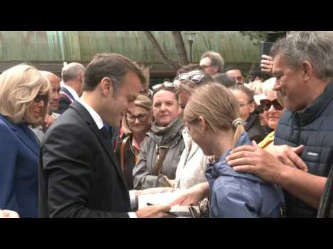 Emmanuel Macron greets residents after casting his vote