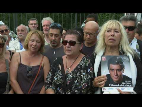 Mourning fans sing 'Paroles, paroles' outside French actor Alain Delon's estate