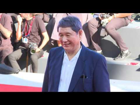 Japanese director Takeshi Kitano walks Venice's red carpet for his movie 'Broken rage'