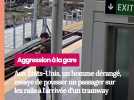 Un homme essaye de pousser un passager sur les rails alors juste au moment de l'approche d'un train en station